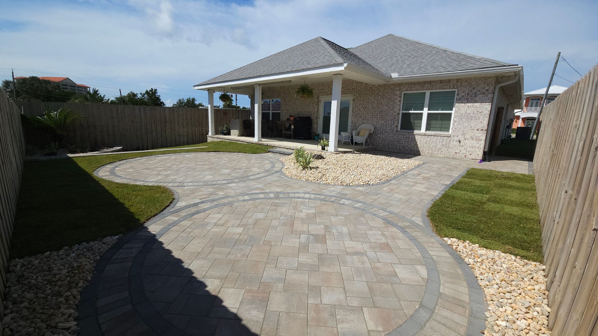 Modern brick house with circular paver patio and landscaped yard