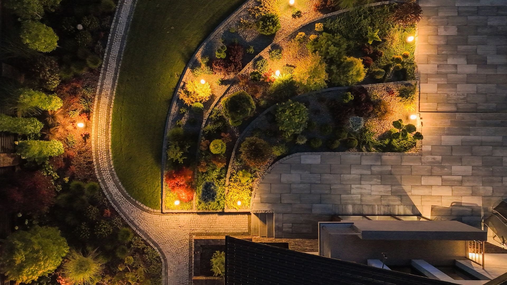 Nighttime aerial view of beautifully landscaped garden with glowing lights