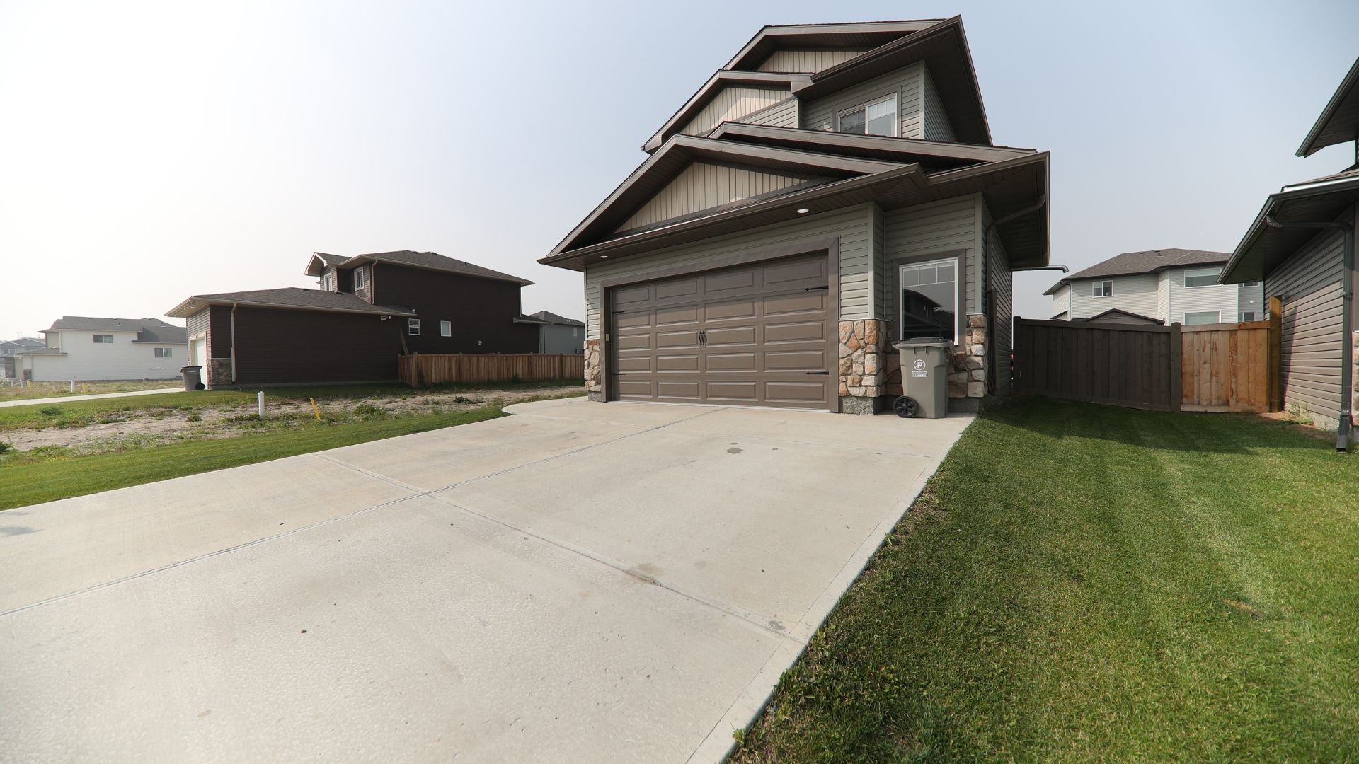 Modern suburban two-story house with double garage and concrete driveway